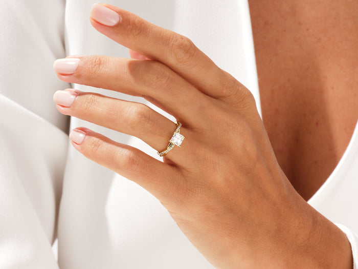Square princess lab grown diamond braided ring in yellow gold worn on a relaxed hand