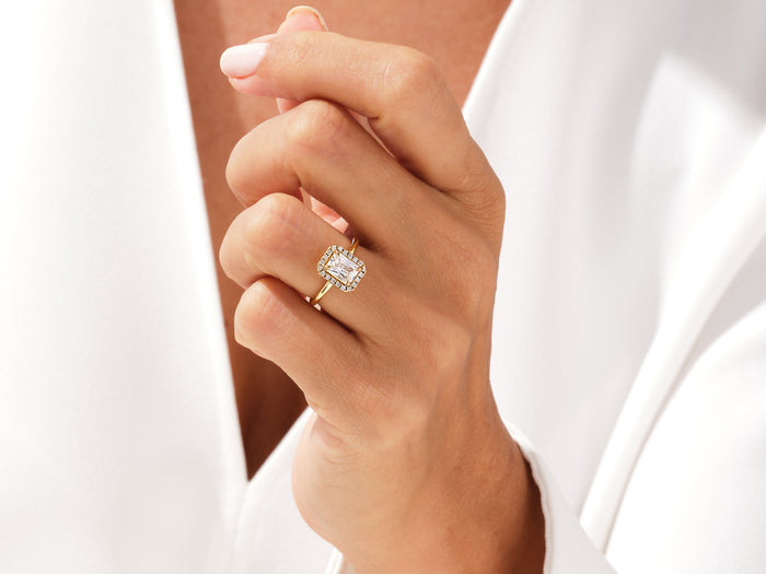 Radiant lab grown diamond pave halo engagement ring worn on the hand raised to the chin