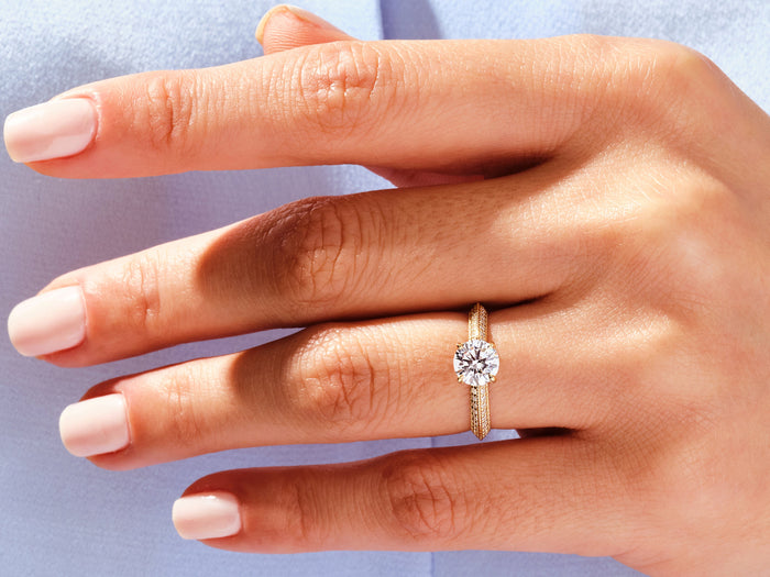 Round lab grown diamond milgrain knife edge pave ring in rose gold worn on the hand