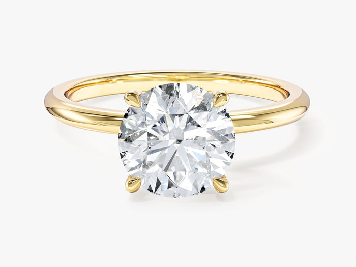 Round lab grown diamond four prong solitaire with thin plain band in yellow gold, front view