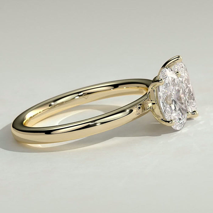 Oval and pear cut moissanite toi et moi engagement ring on a plain yellow gold band, view 2