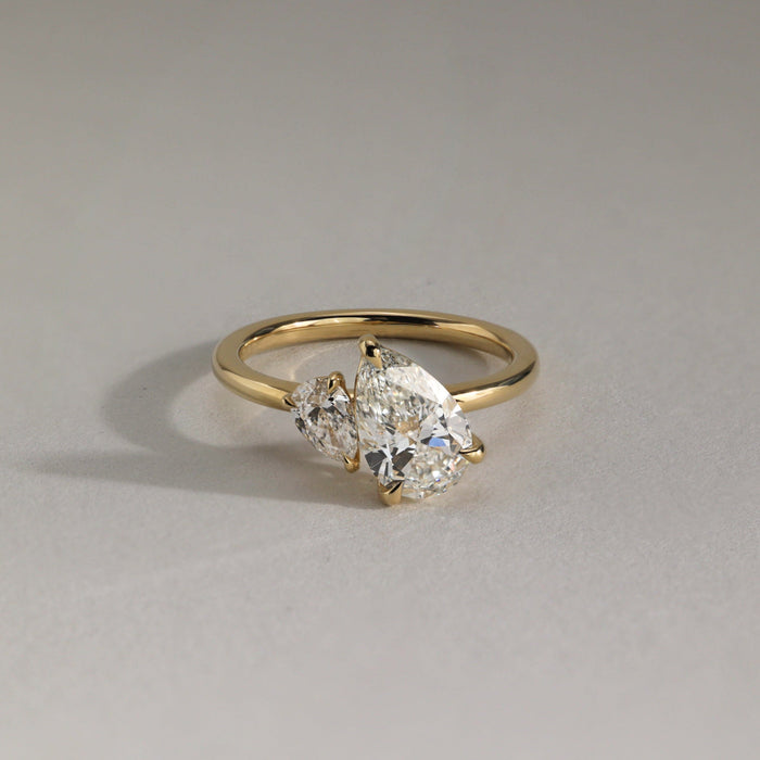Two pear cut moissanite toi et moi engagement ring on a plain yellow gold band, view 2