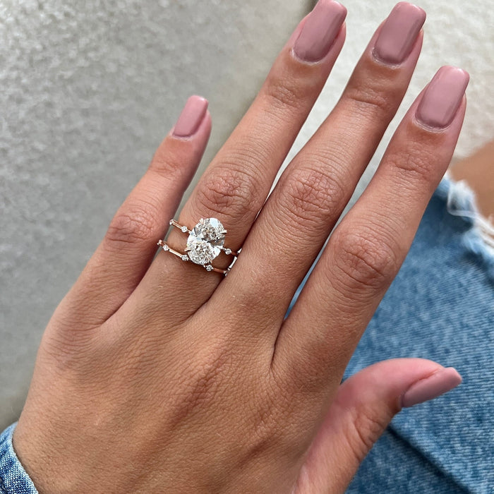 Oval lab grown diamond solitaire and thin station band worn on the flat hand