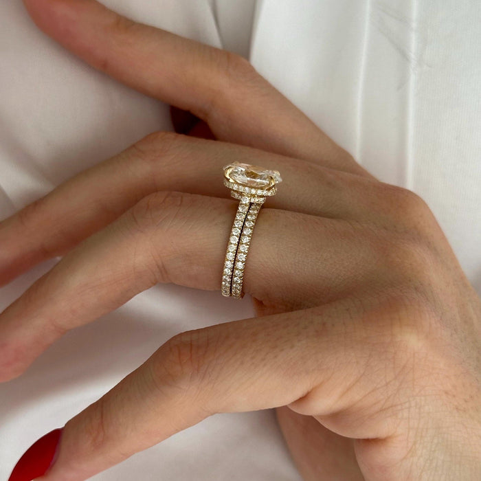 Side view of oval moissanite engagement ring showing the hidden halo and pave shank stacked with the pave wedding band