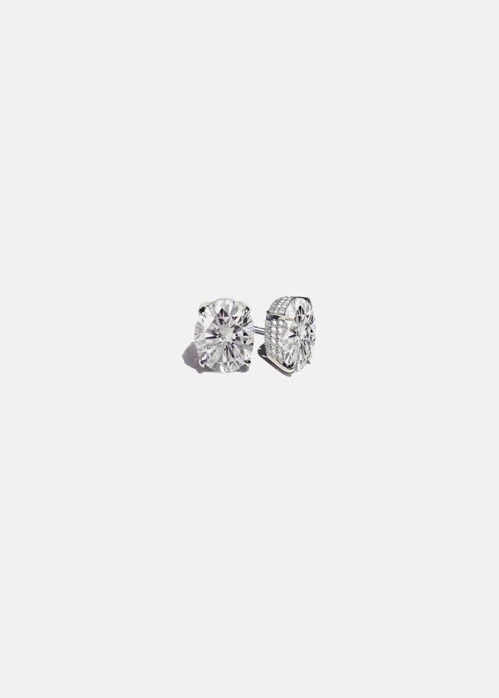 Pair of white gold oval lab grown diamond stud earrings in four prong pave basket settings, one earring turned to show the side