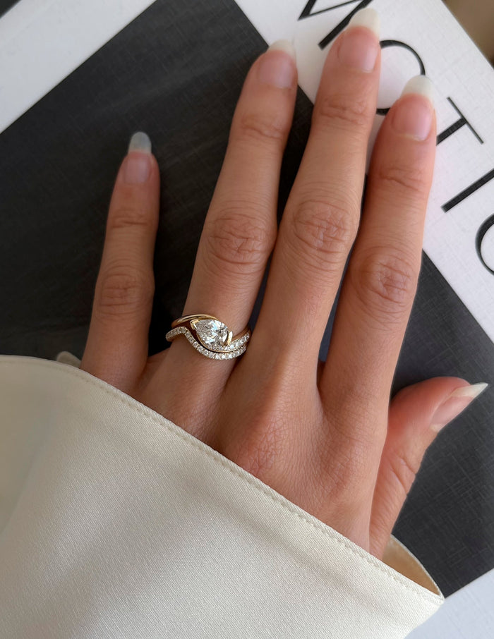 Pear lab grown diamond half pave bypass engagement ring and thin pave wedding band on the full hand