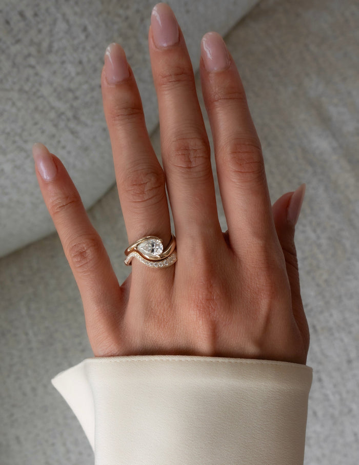 East-west pear lab grown diamond bypass ring and graduated pave band shown on the full hand