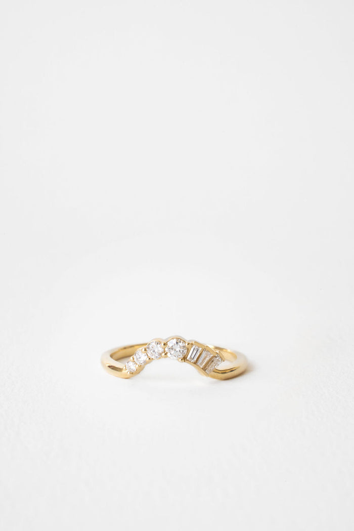 Round and baguette moissanite curved wedding band 0.25 CT TW in yellow gold, front view