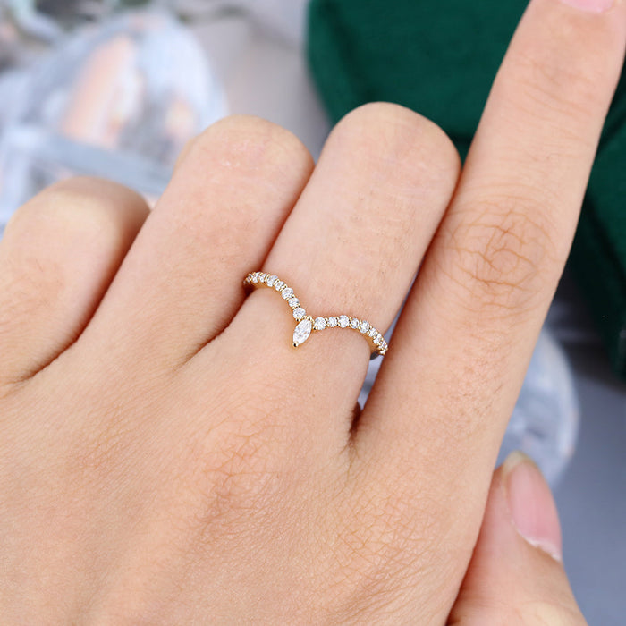 Round and Marquise moissanite marquise drop v curved wedding band, worn on the finger in yellow gold