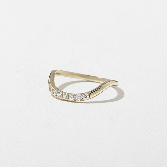 Angled view of the curved band with a row of round moissanite stones