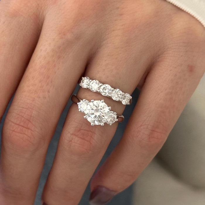 Top view of round moissanite three stone engagement ring and five stone wedding band