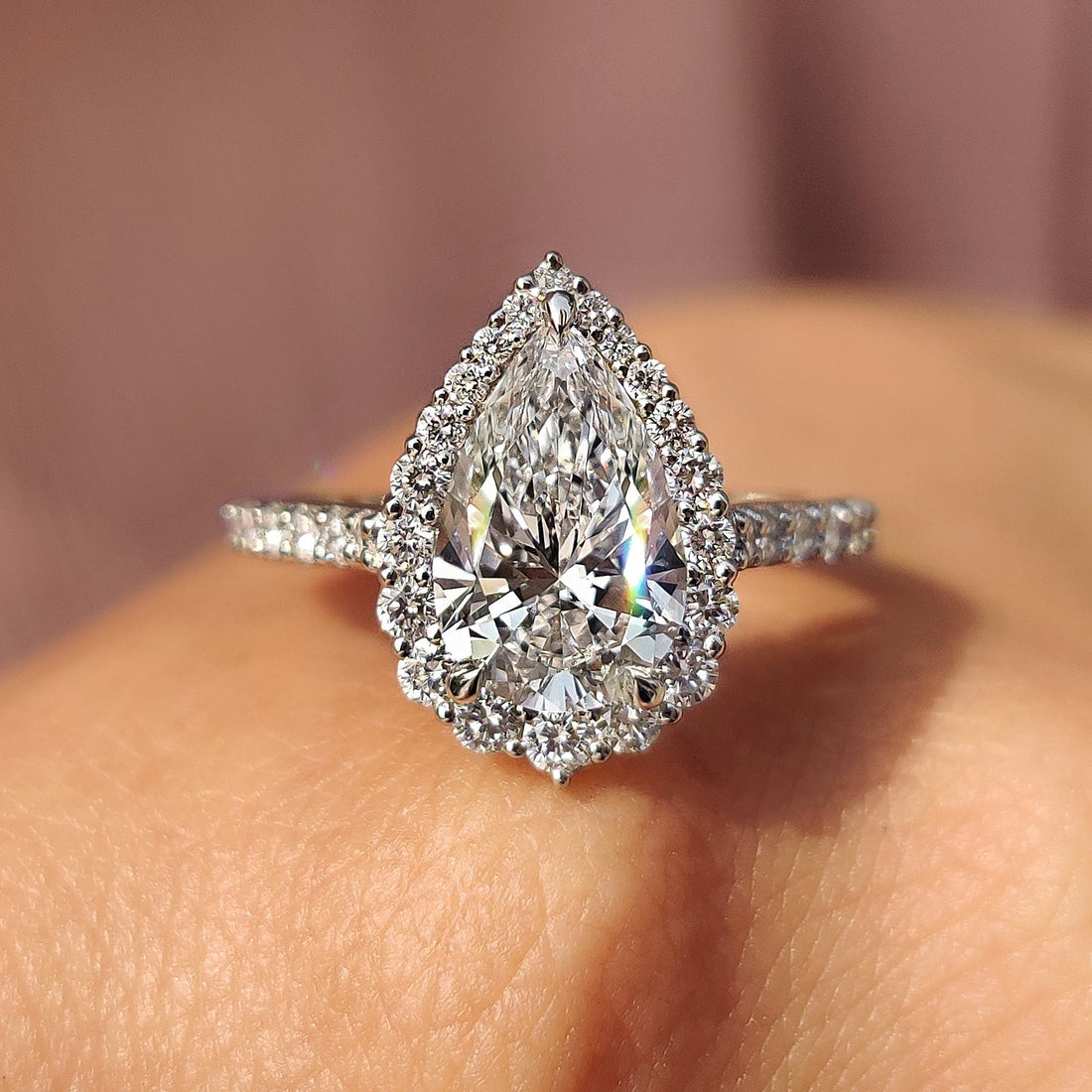 Pear cut lab grown diamond halo and pave engagement ring seen from the front