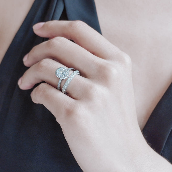 Oval halo pave band engagement ring on the finger