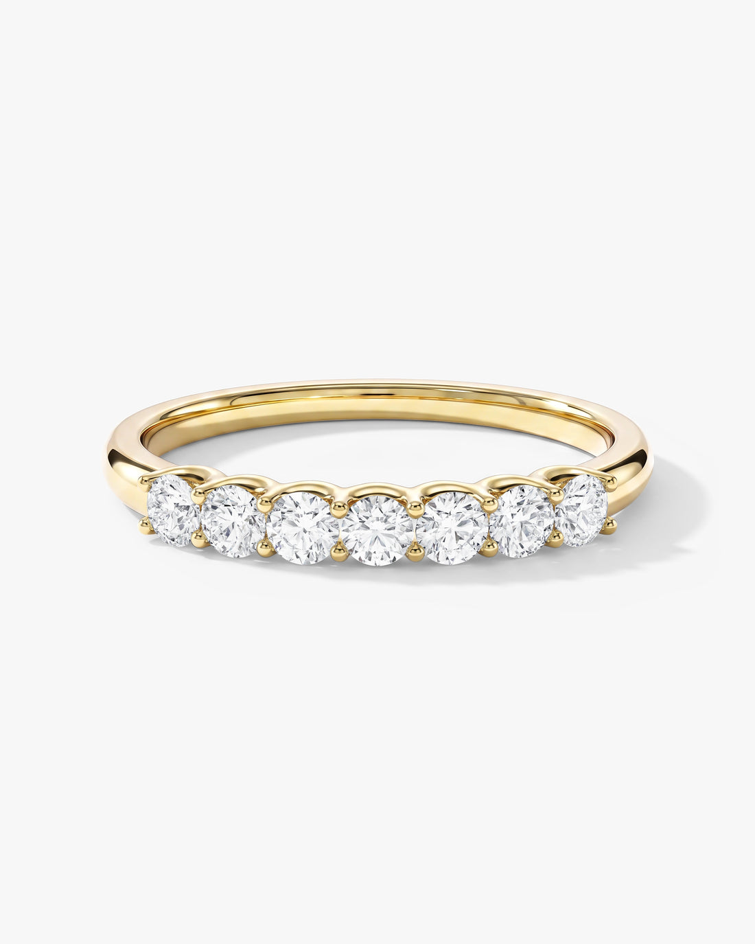 Round moissanite U-prong seven stone anniversary band in yellow gold, front view