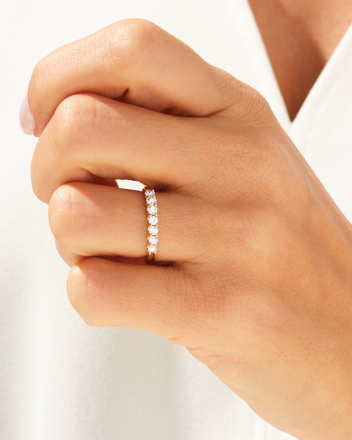 Seven stone moissanite anniversary band worn on a clenched hand