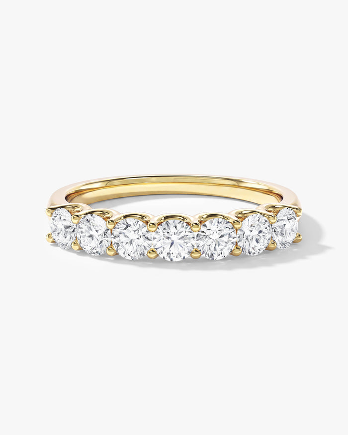 Round moissanite U-prong seven stone anniversary band in yellow gold, front view