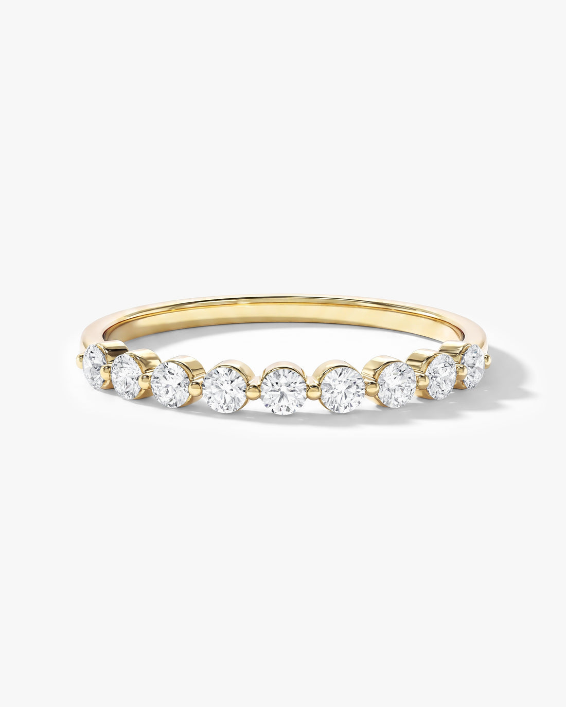 Round moissanite floating nine stone anniversary band in yellow gold, front view