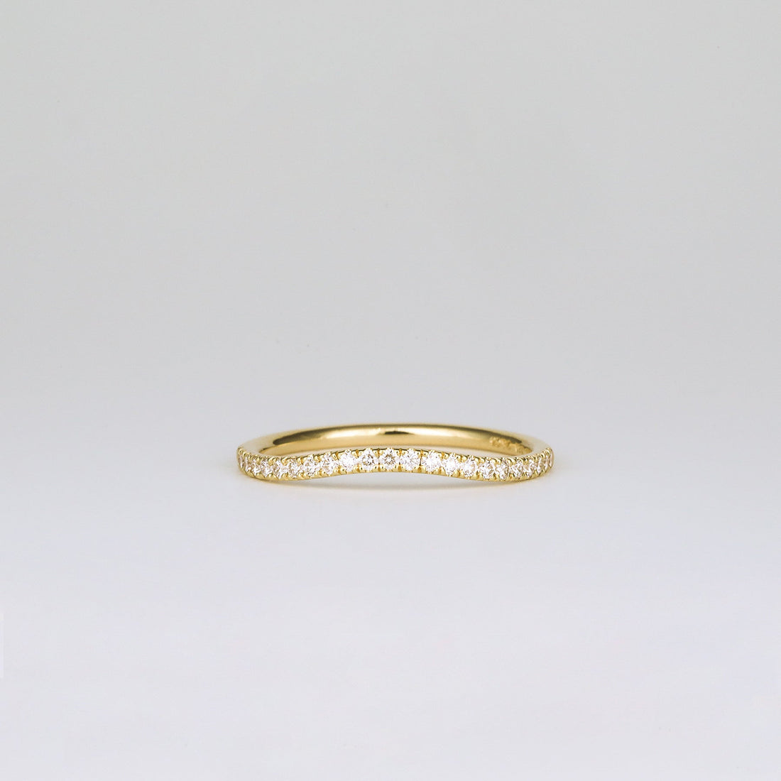 Round lab grown diamond curved pave wedding band in yellow gold, front view