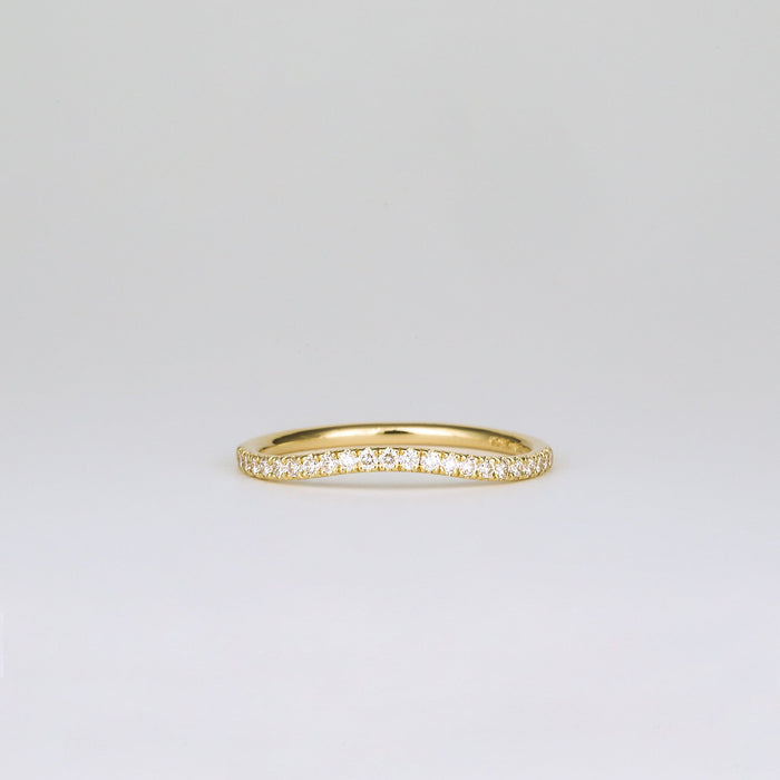 Round moissanite curved pave wedding band in yellow gold, front view