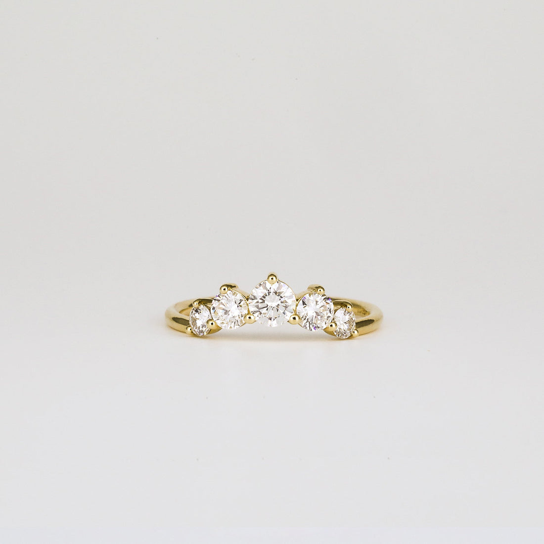 Round lab grown diamond five stone curved wedding band in yellow gold, front view