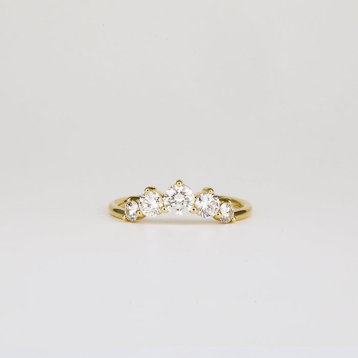Round moissanite five stone curved wedding band in yellow gold, front view