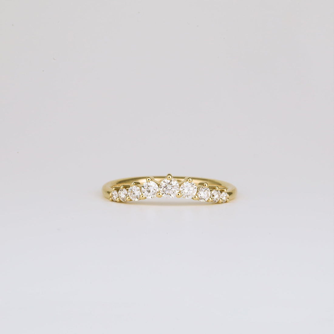 Round lab grown diamond curved wedding band in yellow gold, front view