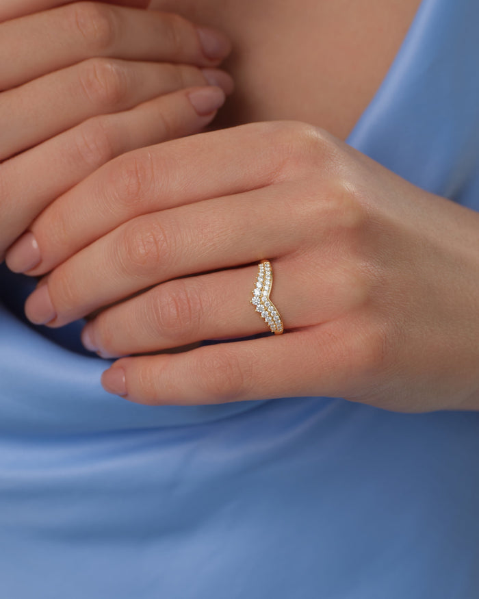 Tiara curved moissanite wedding band worn on a hand, yellow gold