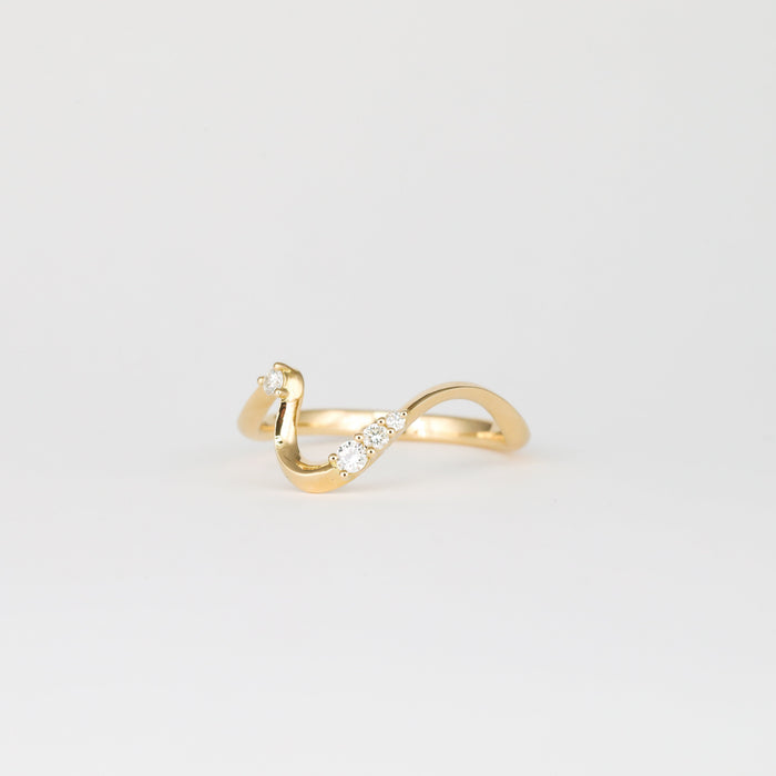 Round moissanite curved wave wedding band in yellow gold, angled view