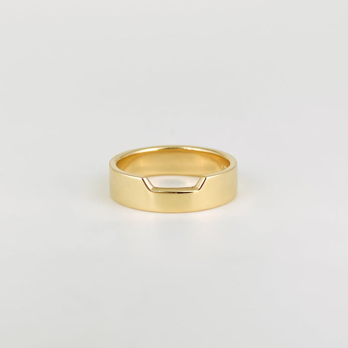 Plain wide contour wedding band with a notched top edge in yellow gold, front view