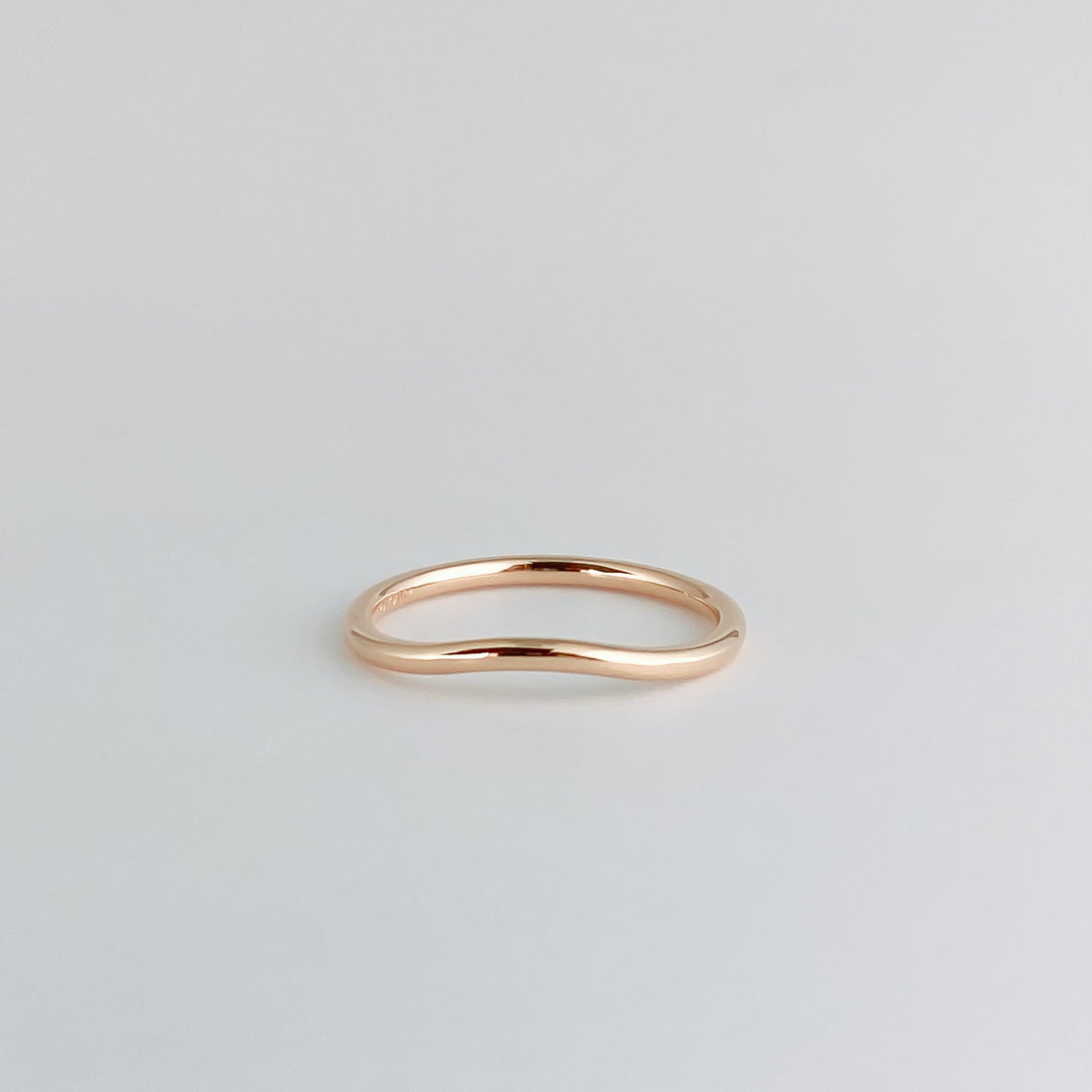 Plain curved wedding band in rose gold, front view