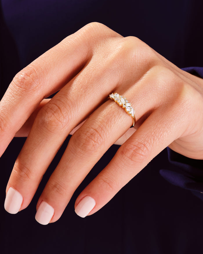 Vintage cluster moissanite wedding band worn on the finger, yellow gold