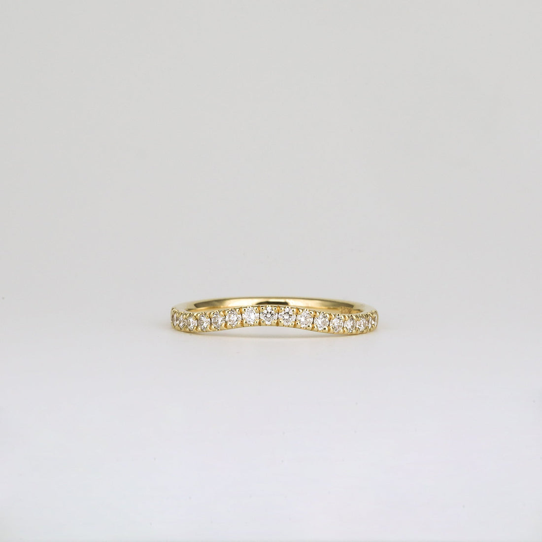 Round lab grown diamond curved pave wedding band in yellow gold, front view