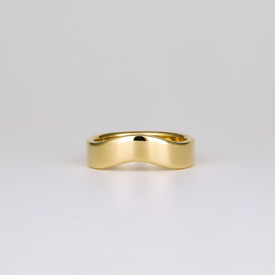 Plain curved contour wedding band in yellow gold, front view