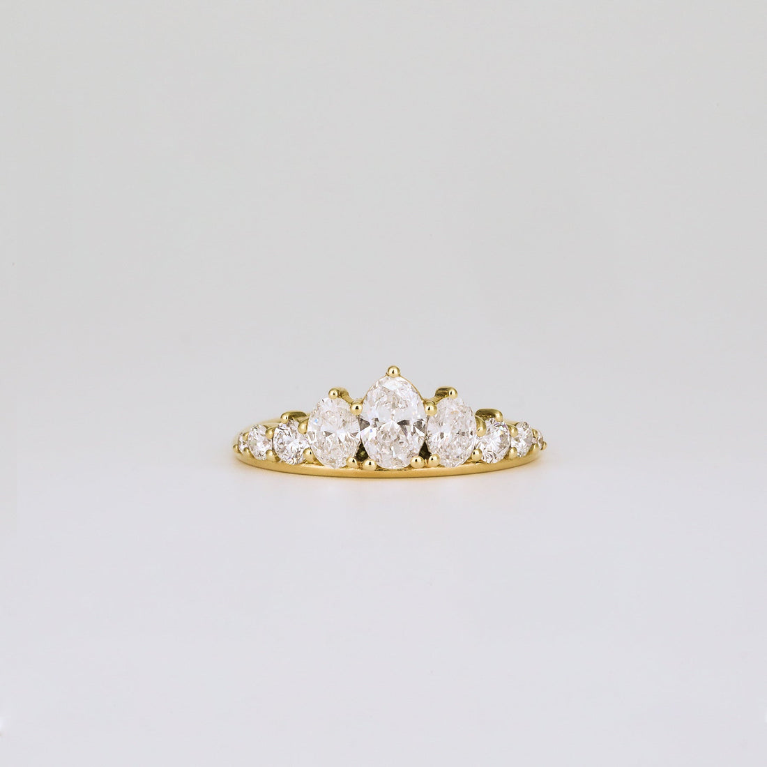 Oval and round lab grown diamond graduated wedding band in yellow gold, front view