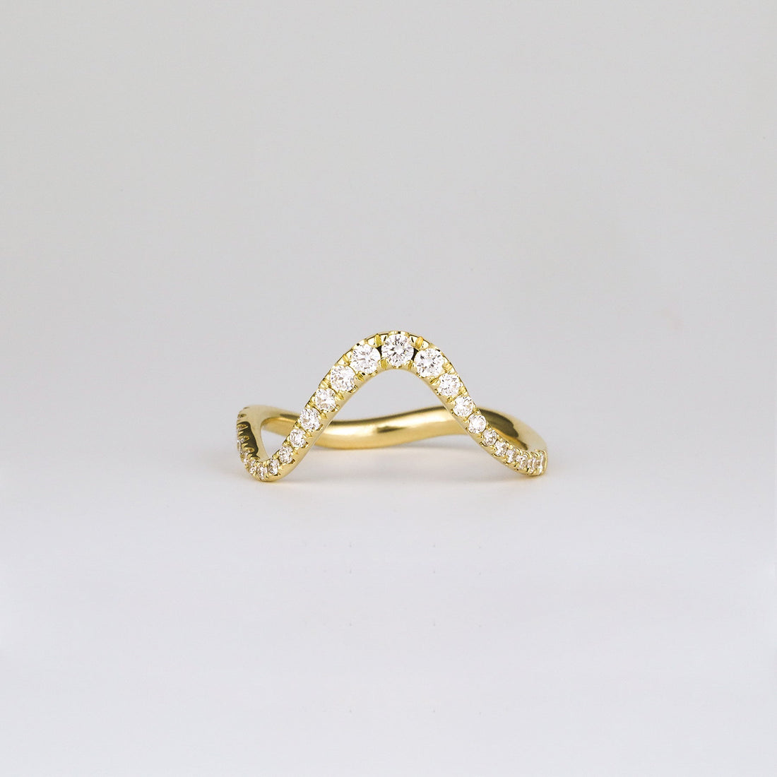 Round lab grown diamond curved wave pave wedding band in yellow gold, front view
