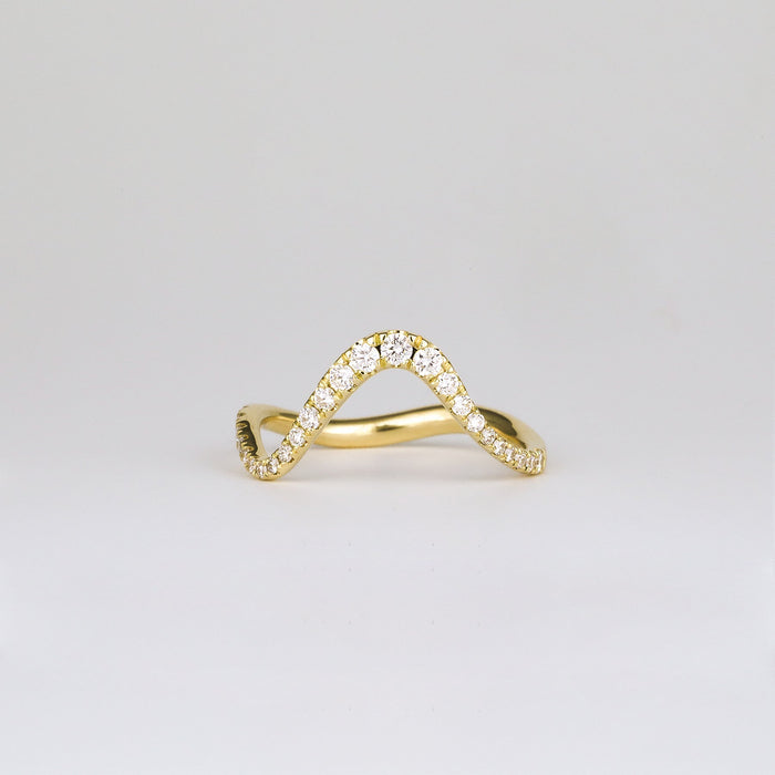 Round moissanite curved wave pave wedding band in yellow gold, front view