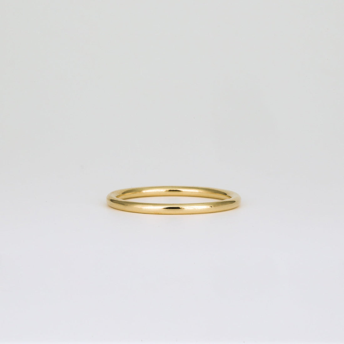 Plain slim round wedding band in yellow gold, front view