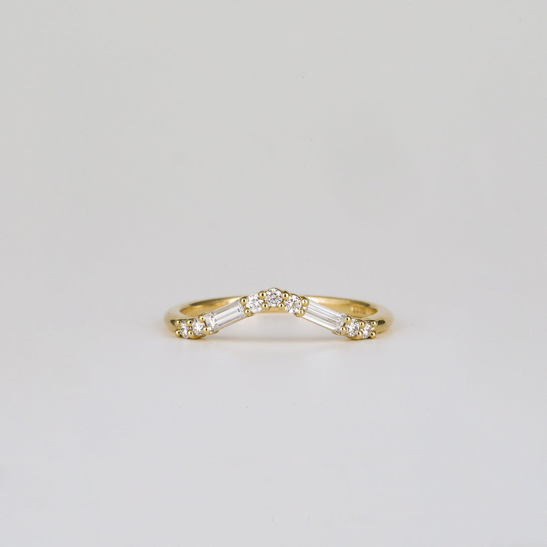 Baguette and round lab grown diamond curved wedding band in yellow gold, front view