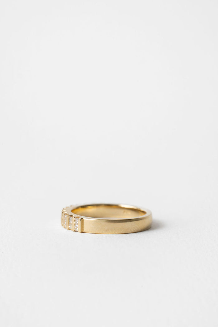 Princess cut moissanite bar channel set wedding band in yellow gold, side view