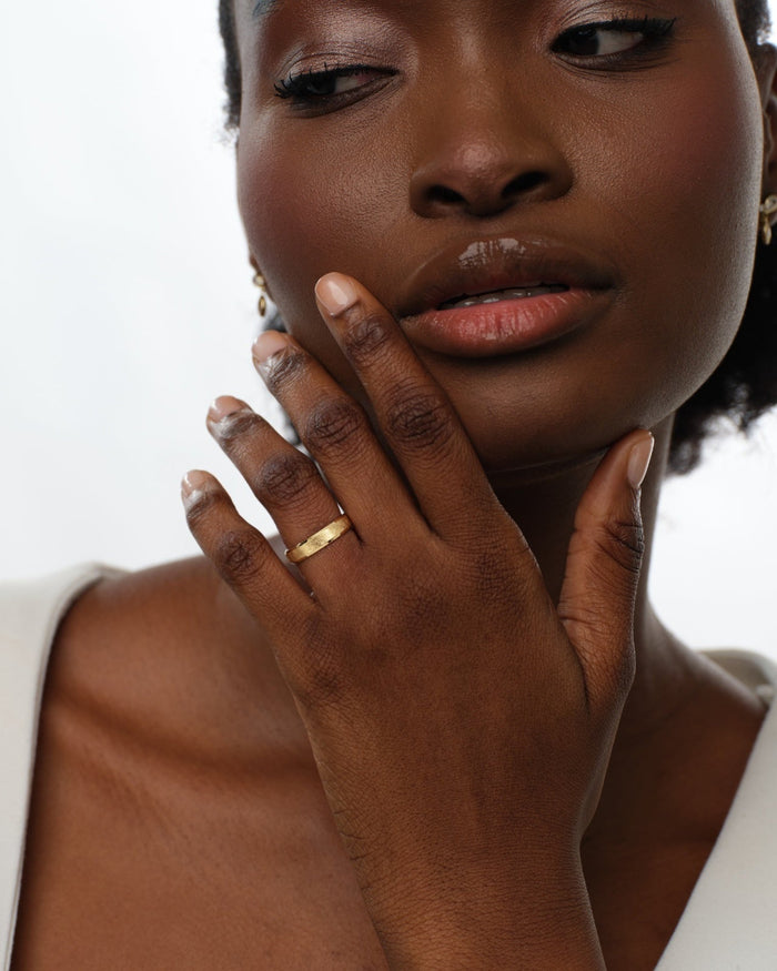 4mm gold ice matte wedding band worn on the hand near the face