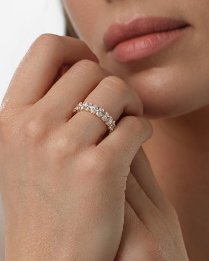 Wide oval moissanite U-prong band worn on the hand