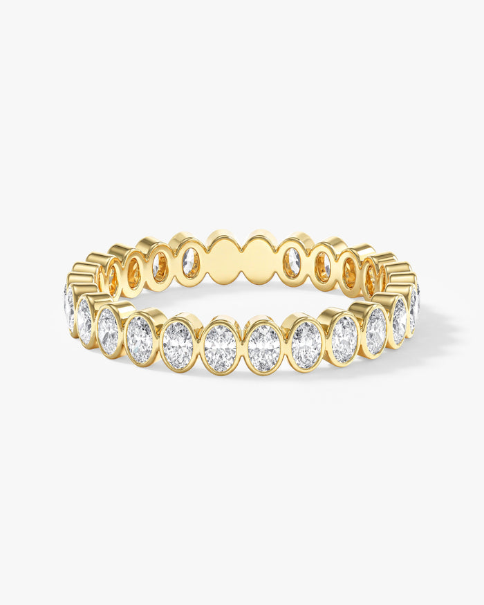 Oval moissanite bezel eternity wedding band in yellow gold, front view