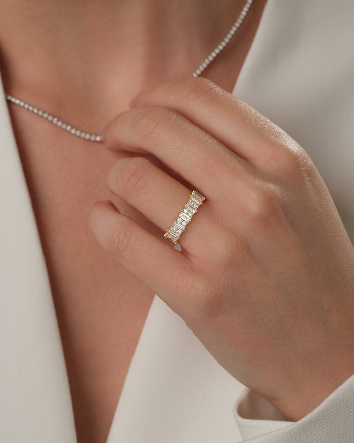 Baguette and round moissanite pillar band worn on a model's hand