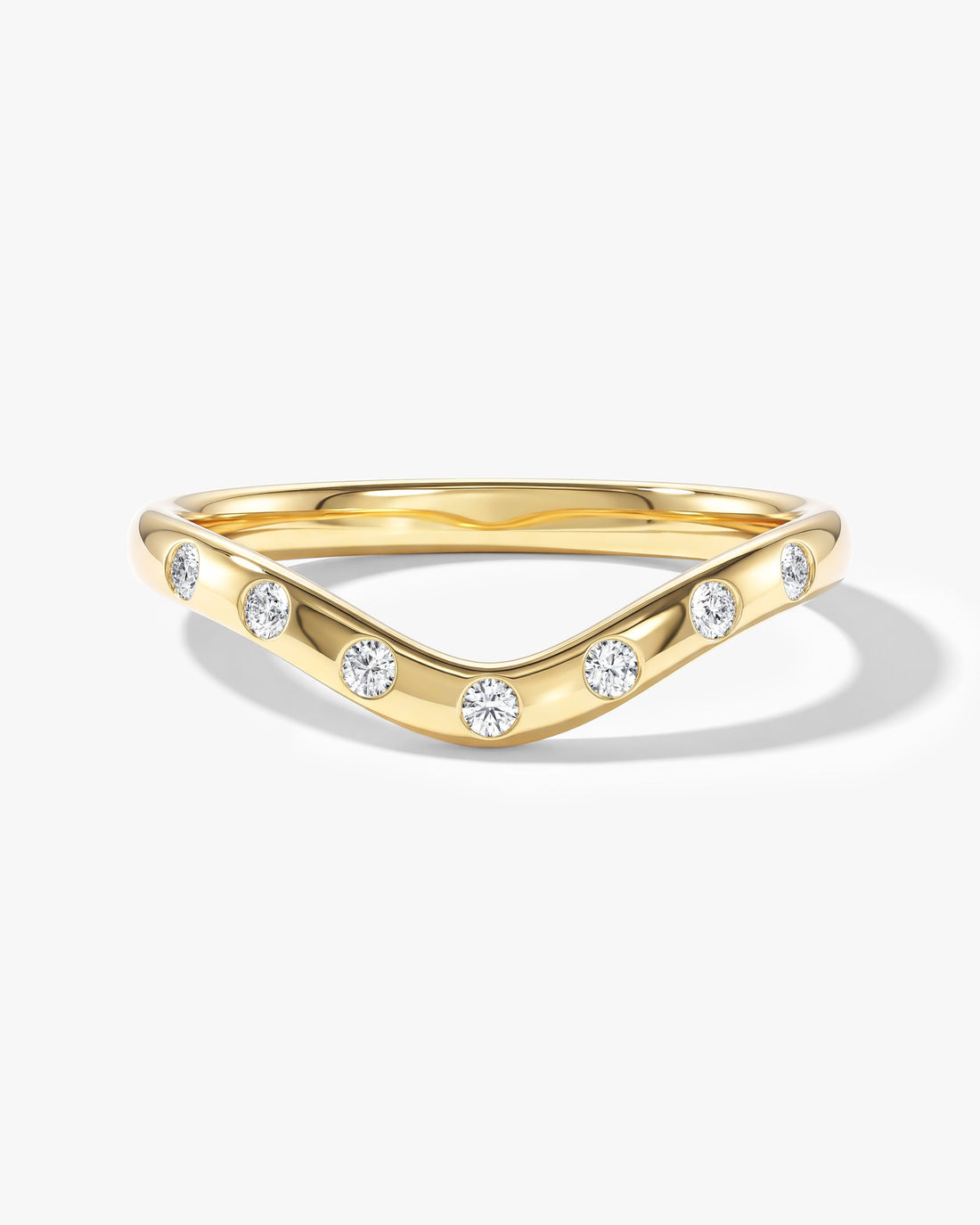 Round moissanite flush set curved wedding band in yellow gold
