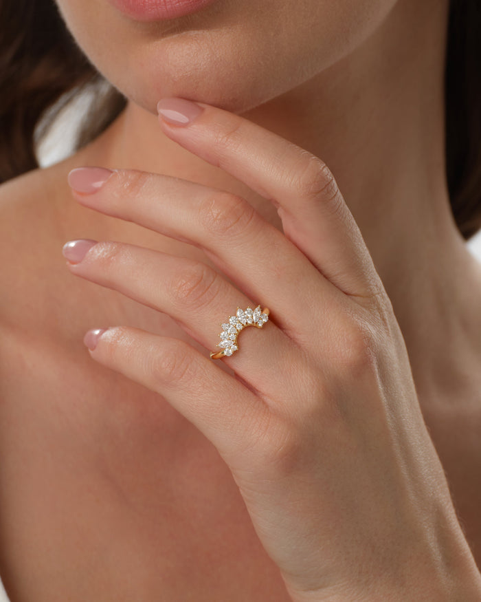Arched crown moissanite wedding band worn on a hand in yellow gold