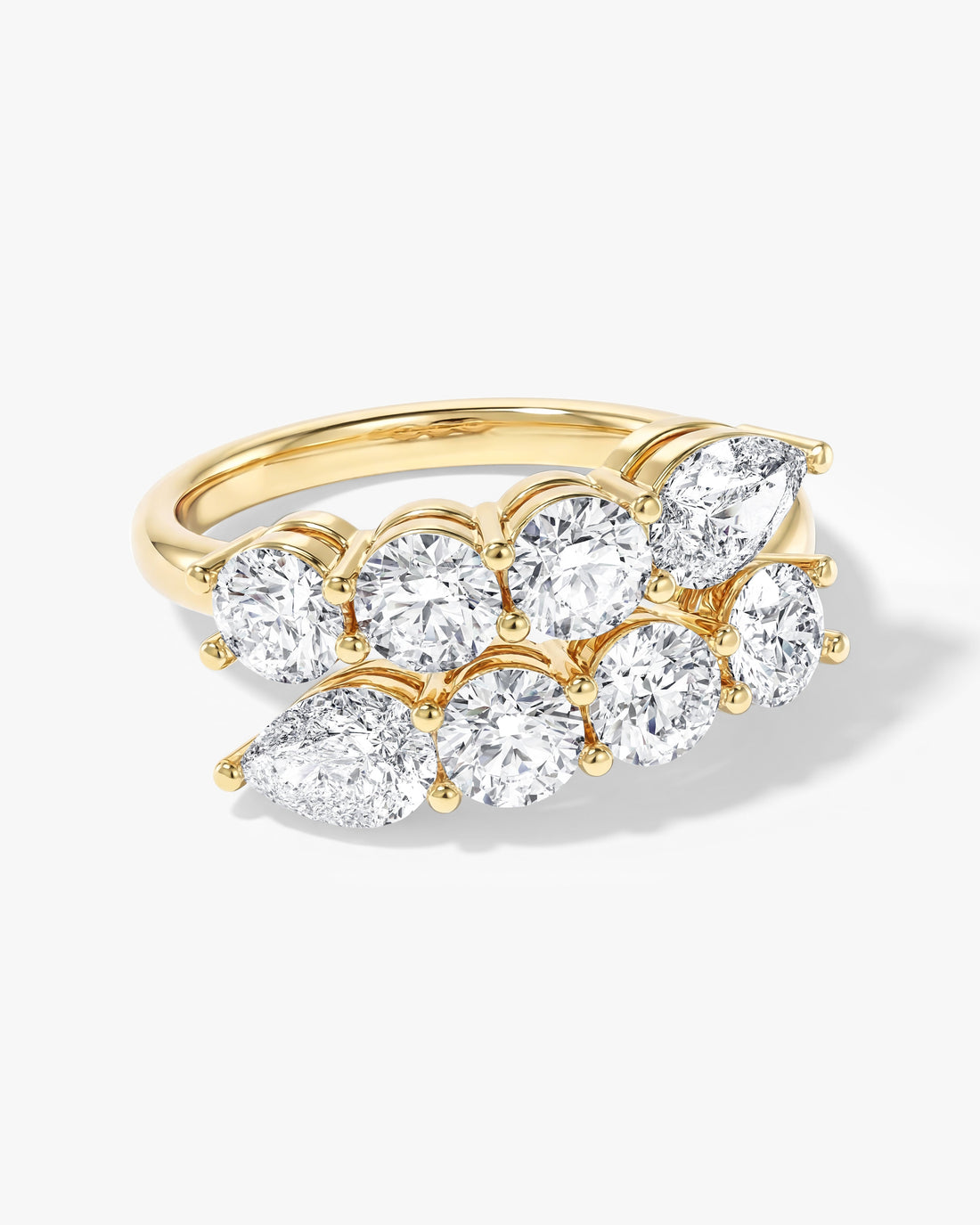 Double row bypass wedding band with pear and round moissanite in yellow gold, angled front view