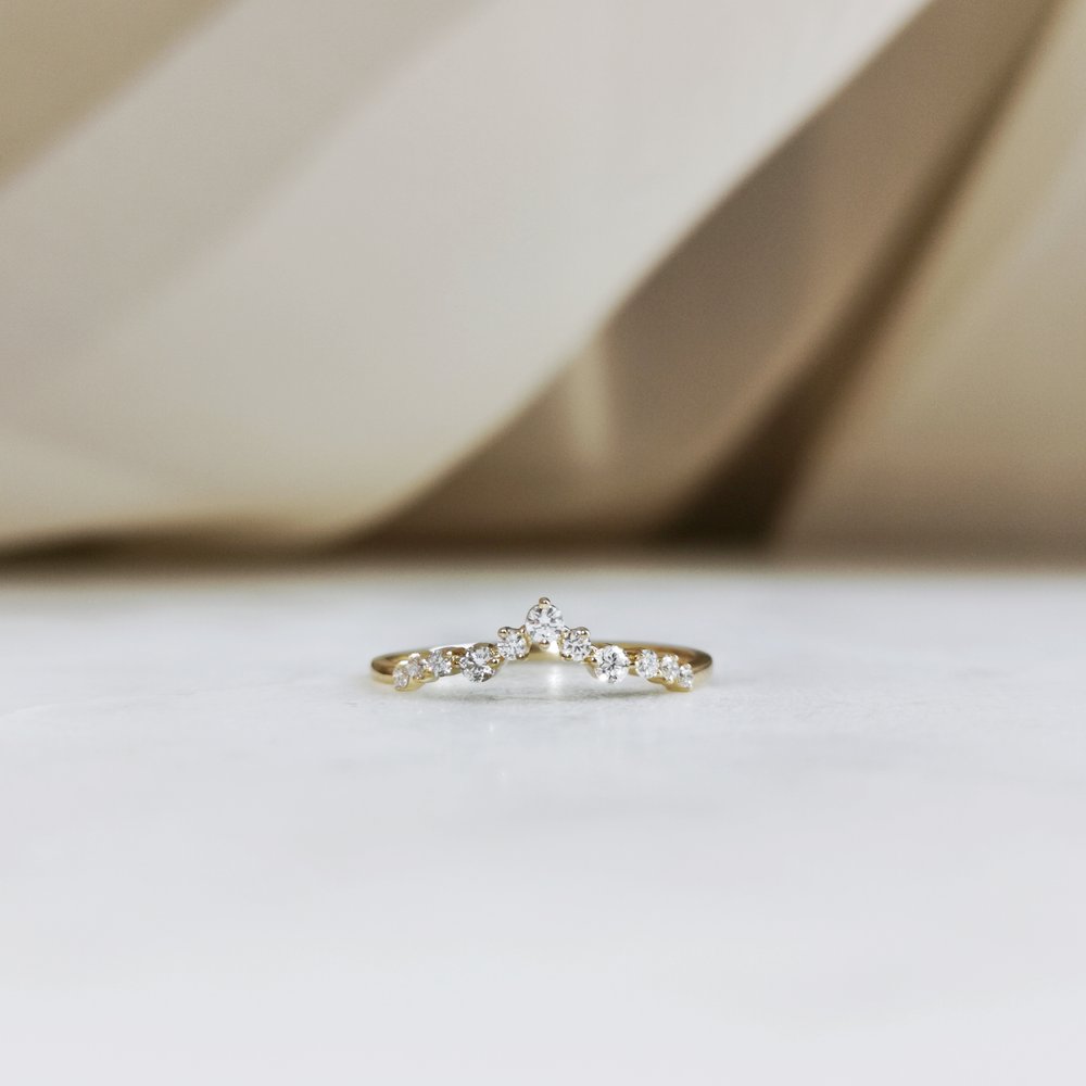 Round lab grown diamond curved wedding band in yellow gold front view