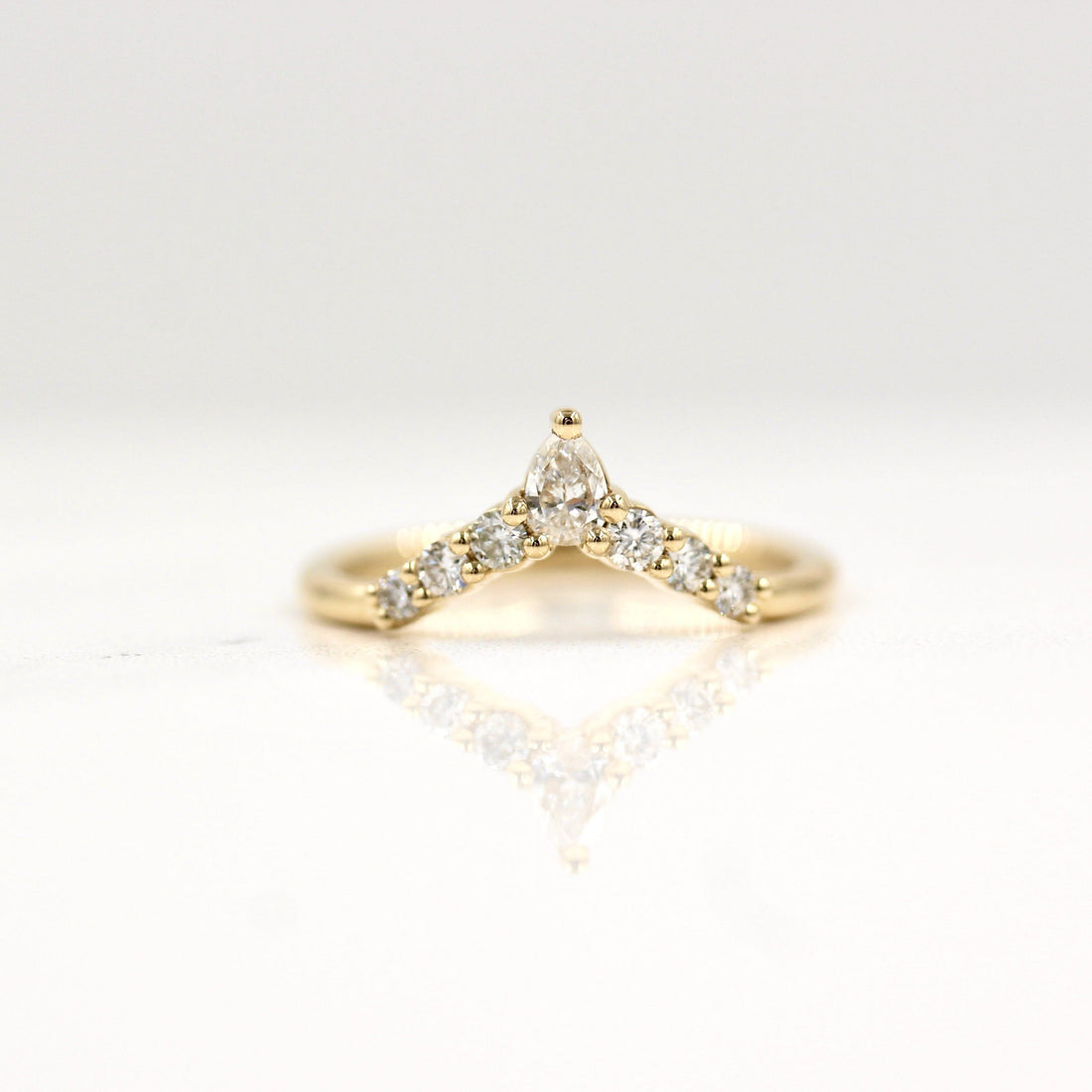 Round and pear lab grown diamond curved V wedding band in yellow gold, pear stone at the top
