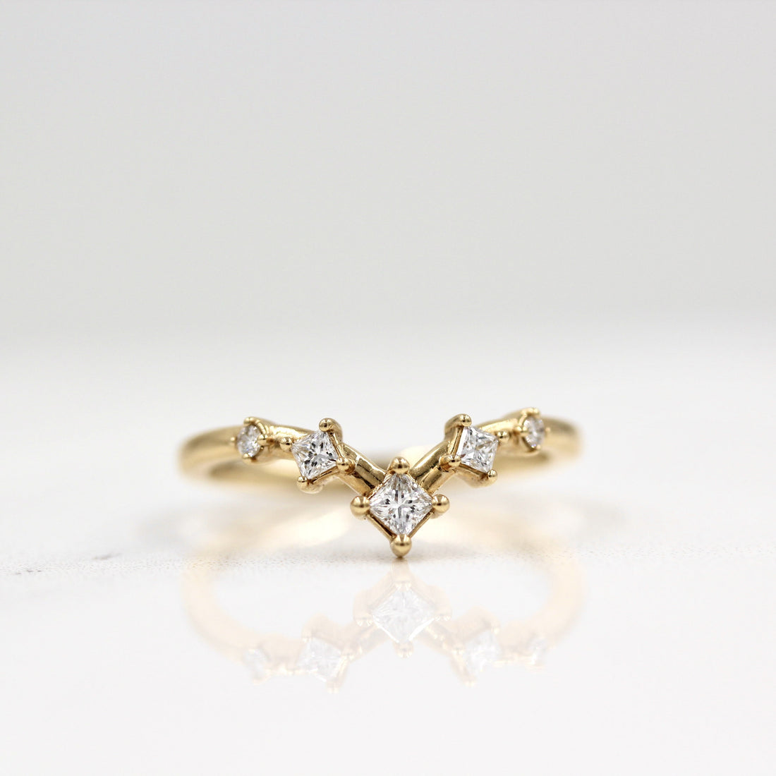 Princess and round lab grown diamond curved V wedding band in yellow gold, front view