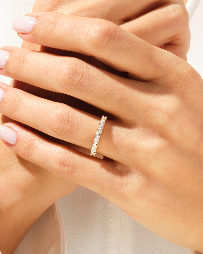 Nine stone moissanite anniversary band worn on a finger